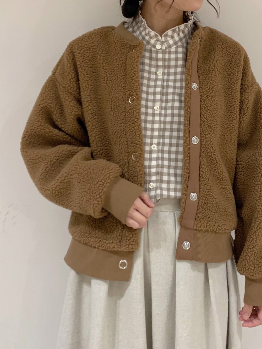 イエロー系のブルゾン、ベージュ系のシャツ/ブラウス、ベージュ系のスカートを着用したレディースの冬コーディネートの5枚目の写真