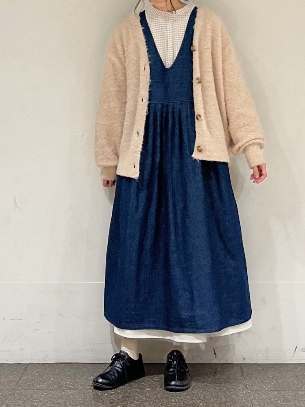 ブルー系のワンピース、ベージュ系のシャツ/ブラウス、ホワイト系のカーディガン/ボレロを着用したレディースの冬コーディネートの2枚目の写真