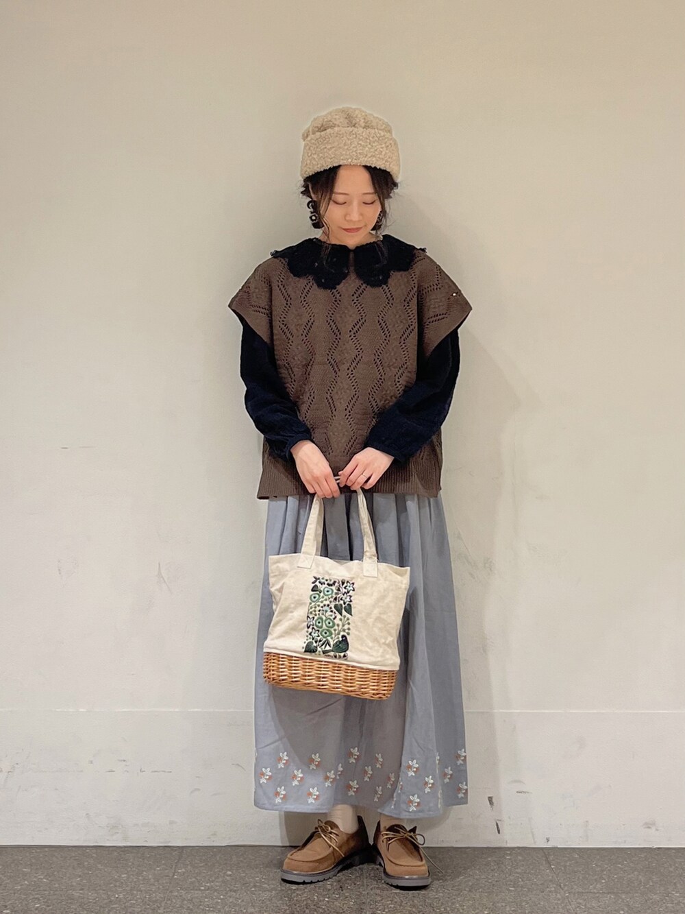 ブラック系のシャツ/ブラウス、ブラウン系のベスト、ブルー系のスカートを着用したレディースの秋コーディネートの2枚目の写真