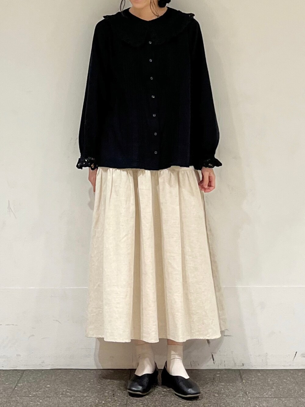 ブラック系のシャツ/ブラウス、ベージュ系のスカートを着用したレディースの冬コーディネートの2枚目の写真