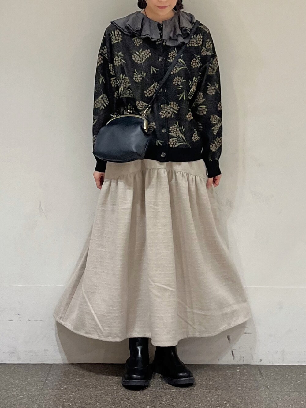 ブラック系のカーディガン/ボレロ、グレー系のシャツ/ブラウス、ホワイト系のスカートを着用したレディースの冬コーディネートの4枚目の写真