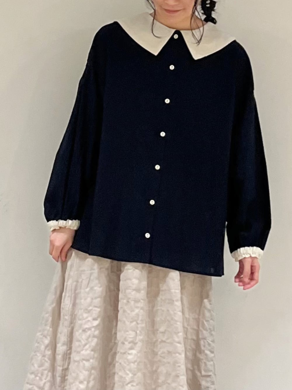 ブラック系のシャツ/ブラウス、ベージュ系のスカートを着用したレディースの冬コーディネートの5枚目の写真