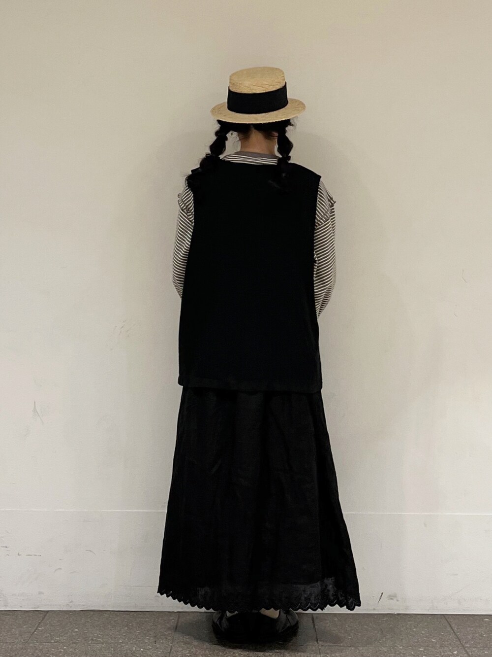 ブラウン系のTシャツ/カットソー、グレー系のベスト、ブラック系のスカートを着用したレディースの春コーディネートの3枚目の写真