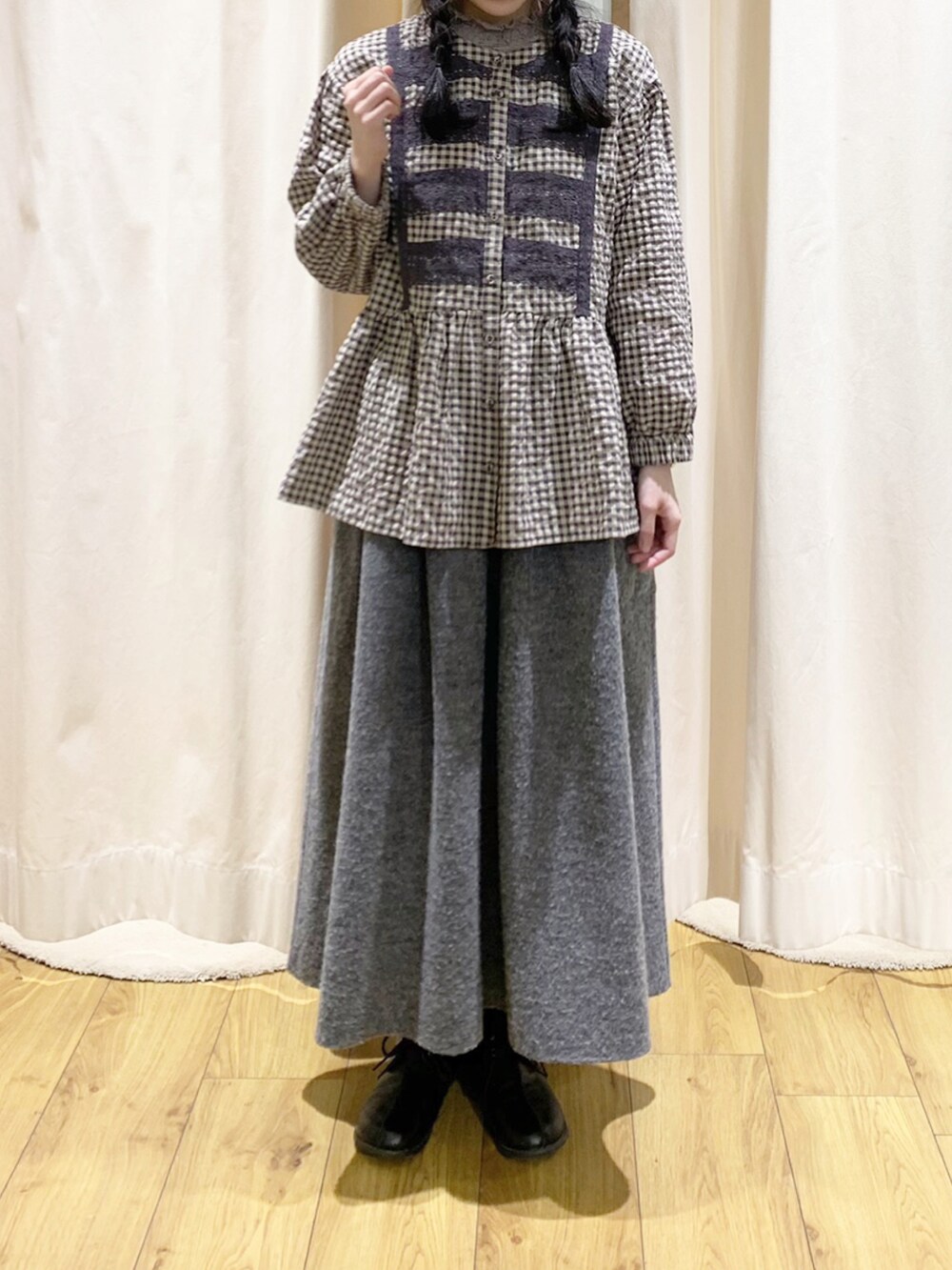 ブラウン系のカーディガン/ボレロ、グレー系のシャツ/ブラウス、ブラック系のスカートを着用したレディースの冬コーディネートの5枚目の写真