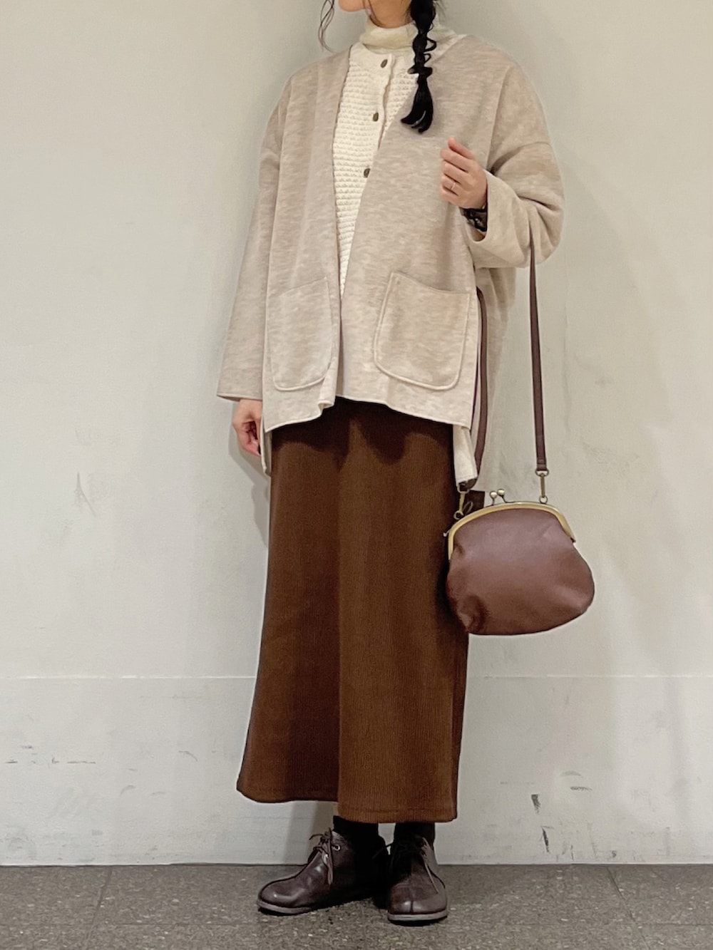 ブラウン系のスカート、ホワイト系のカーディガン/ボレロ、ベージュ系のノーカラージャケットを着用したレディースの秋コーディネートの3枚目の写真