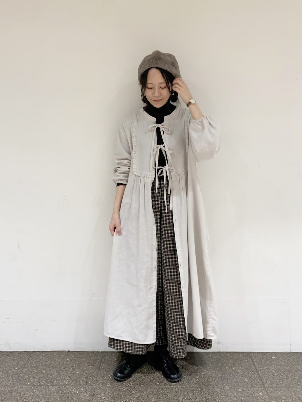 グレー系のワンピース、グレー系のニット/セーター、ブラウン系のスカートを着用したレディースの冬コーディネートの2枚目の写真