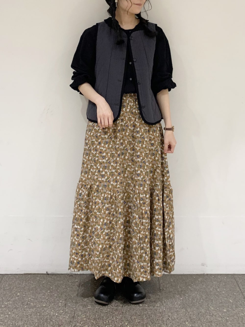 ブラック系のシャツ/ブラウス、グレー系のベスト、ベージュ系のスカートを着用したレディースの冬コーディネートの2枚目の写真