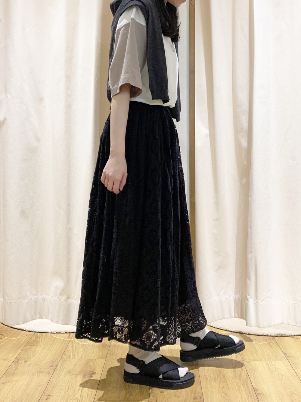 グレー系のニット/セーター、グレー系のカーディガン/ボレロ、ホワイト系のTシャツ/カットソーを着用したレディースの春コーディネートの2枚目の写真