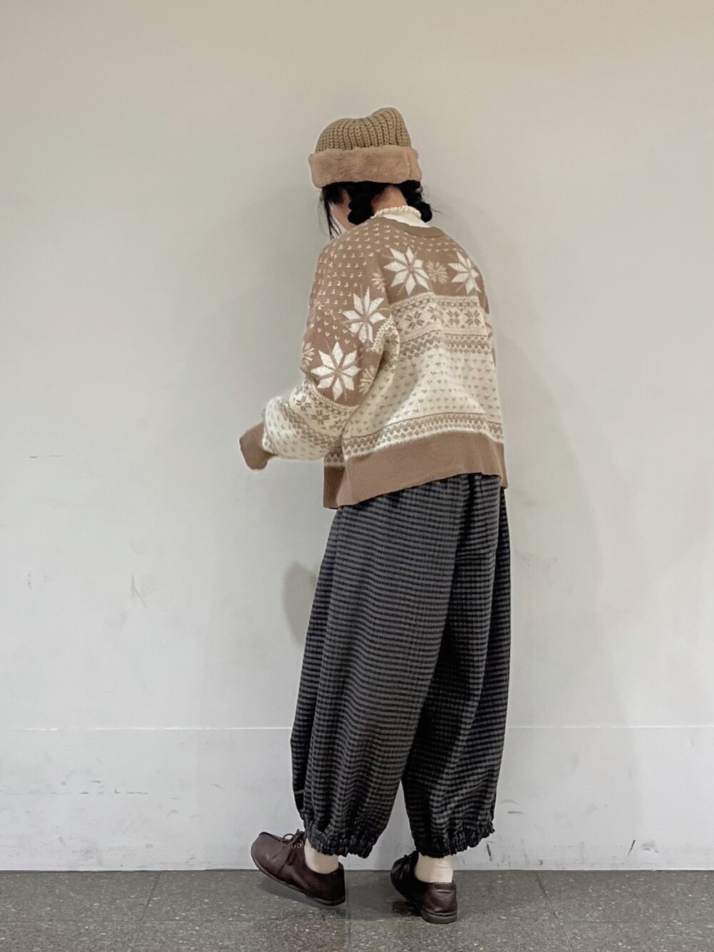 ブラウン系のカーディガン/ボレロ、ホワイト系のニット/セーター、ブラウン系のその他パンツを着用したレディースの冬コーディネートの3枚目の写真