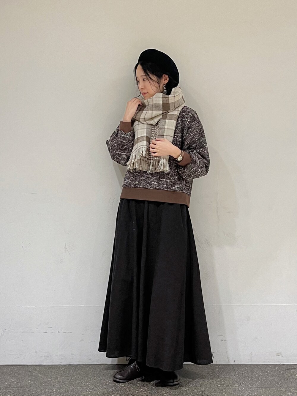 ブラウン系のTシャツ/カットソー、グレー系のスカート、ベージュ系のストール/ショールを着用したレディースの秋コーディネートの2枚目の写真