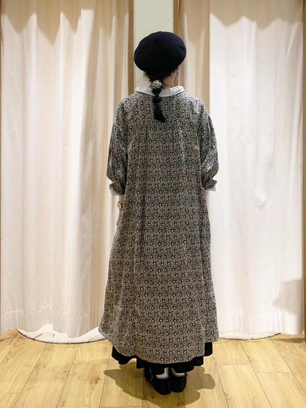 グレー系のワンピース、ホワイト系のシャツ/ブラウス、ブラック系のスカートを着用したレディースの秋コーディネートの4枚目の写真