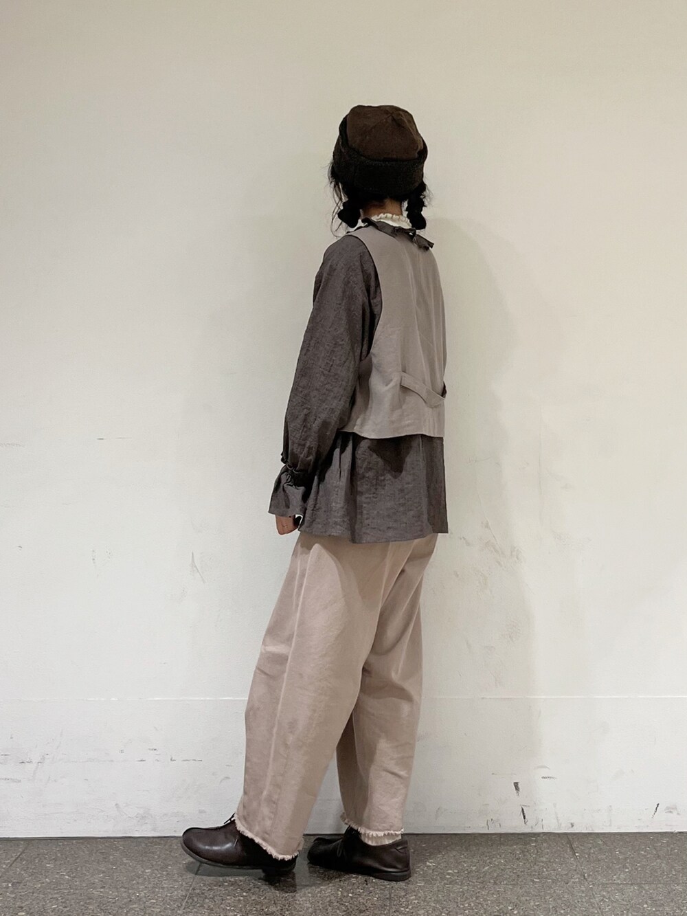 ブラウン系のシャツ/ブラウス、ブラウン系のベスト、ホワイト系のニット/セーターを着用したレディースの冬コーディネートの3枚目の写真