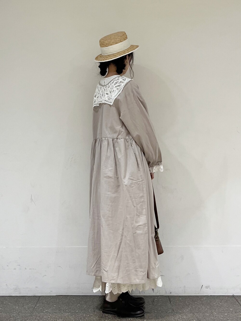 ホワイト系のワンピース、ホワイト系のスカート、ブラウン系のハンドバッグを着用したレディースの冬コーディネートの4枚目の写真