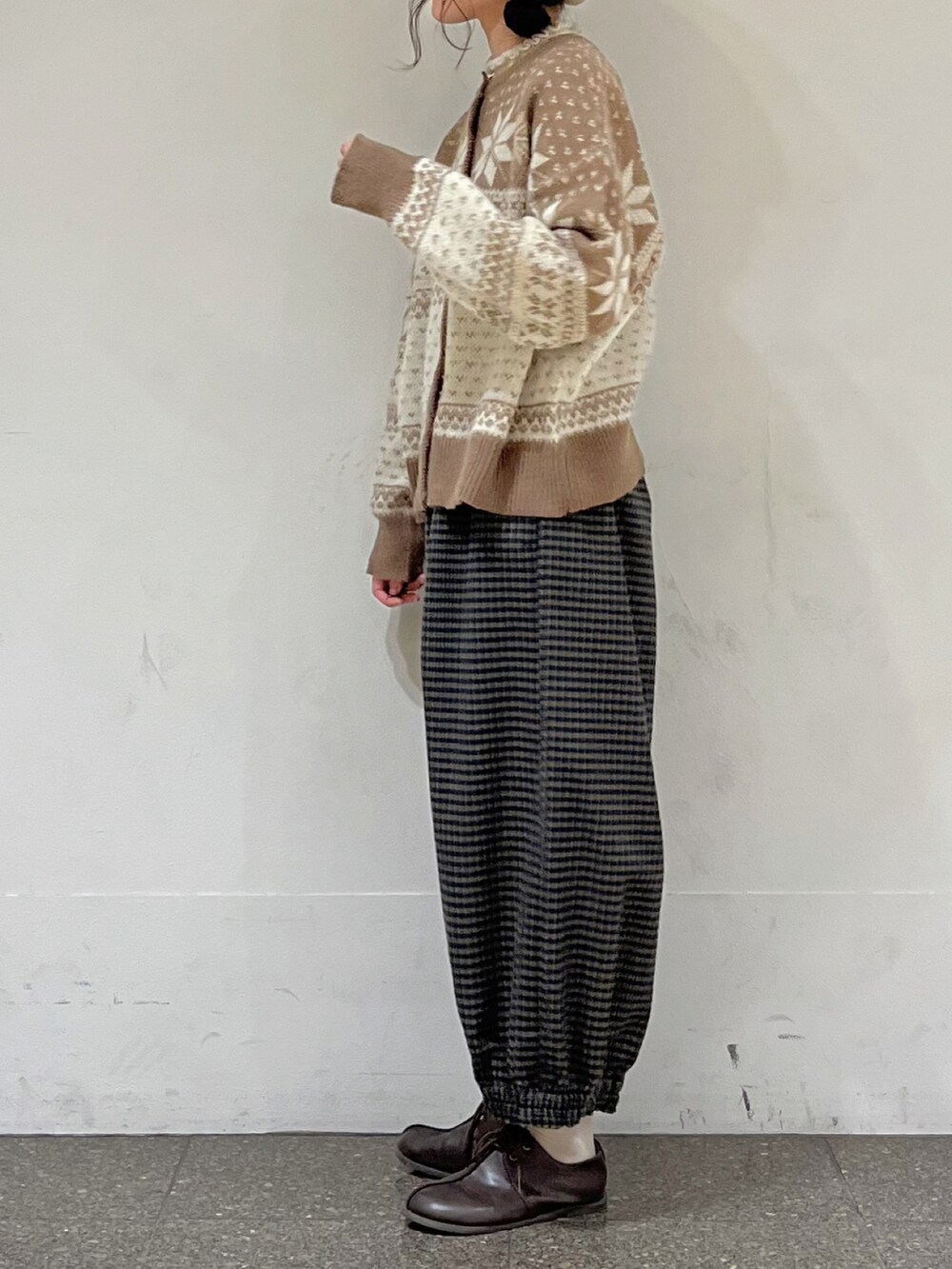 ブラウン系のカーディガン/ボレロ、ホワイト系のニット/セーター、ブラウン系のその他パンツを着用したレディースの冬コーディネートの4枚目の写真