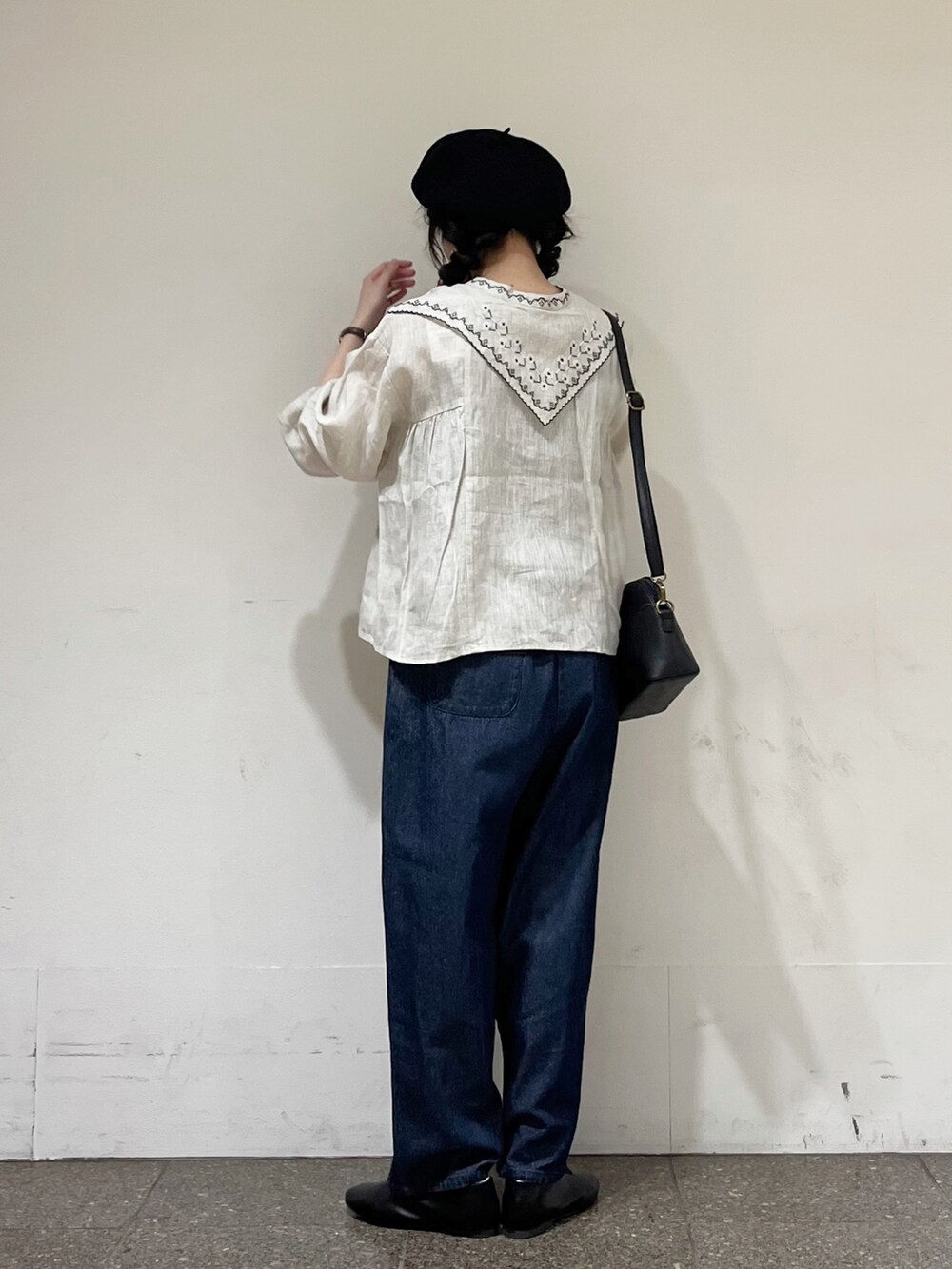 ベージュ系のシャツ/ブラウス、ブルー系のデニムパンツ、ブラック系のハンドバッグを着用したレディースの冬コーディネートの3枚目の写真