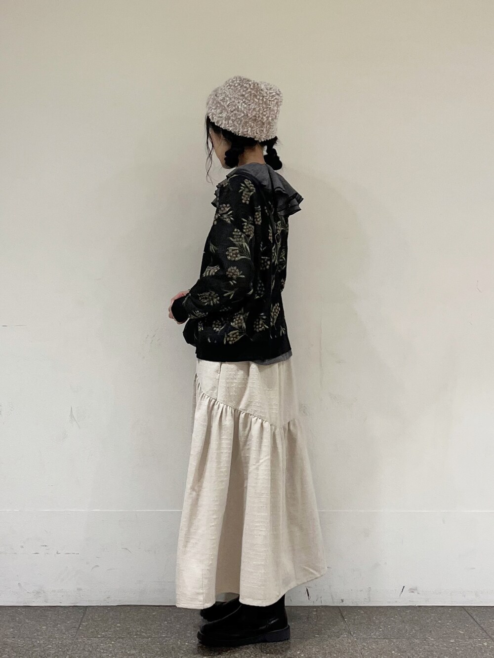 ブラック系のカーディガン/ボレロ、グレー系のシャツ/ブラウス、ホワイト系のスカートを着用したレディースの冬コーディネートの2枚目の写真