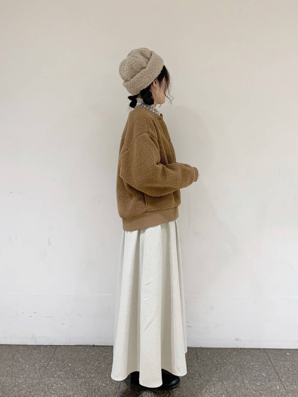 イエロー系のブルゾン、ベージュ系のシャツ/ブラウス、ベージュ系のスカートを着用したレディースの冬コーディネートの3枚目の写真