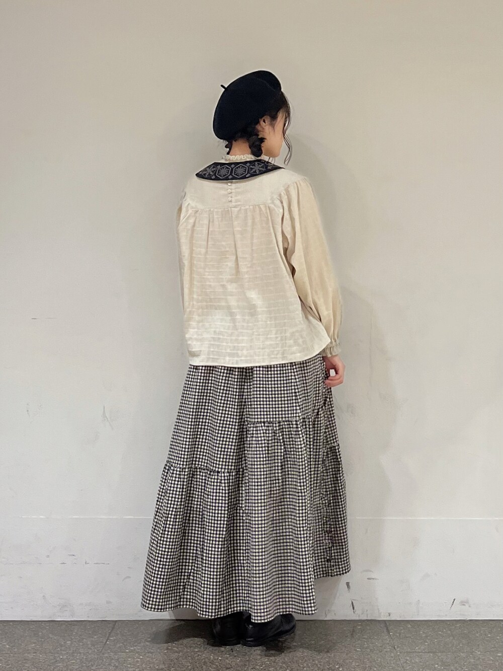 ベージュ系のシャツ/ブラウス、ブラック系のスカート、グレー系のカーディガン/ボレロを着用したレディースの冬コーディネートの3枚目の写真