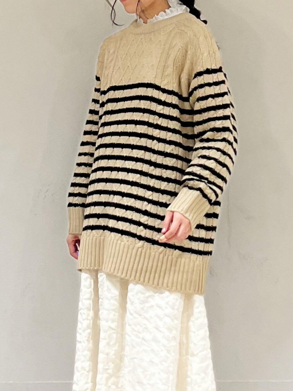 ベージュ系のニット/セーター、ホワイト系のシャツ/ブラウス、ホワイト系のスカートを着用したレディースの冬コーディネートの5枚目の写真