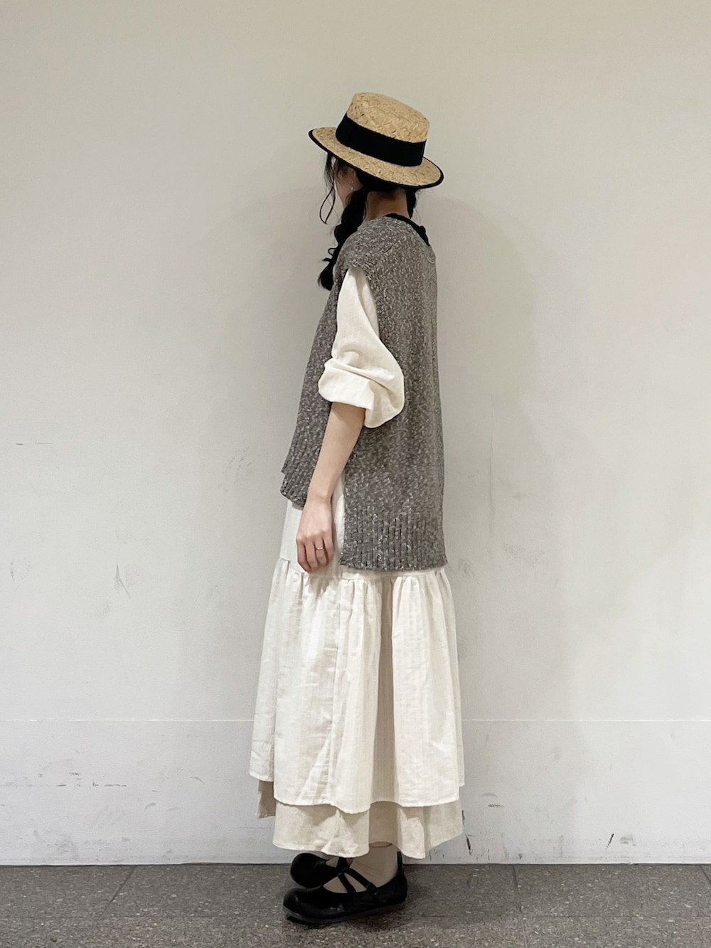 ブラウン系のベスト、ホワイト系のワンピース、ベージュ系のスカートを着用したレディースの冬コーディネートの3枚目の写真