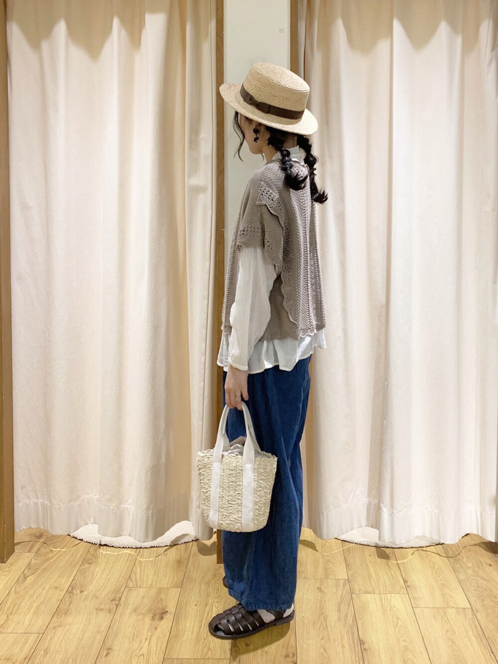 ブラウン系のベスト、ホワイト系のシャツ/ブラウス、ブルー系のデニムパンツを着用したレディースの春コーディネートの3枚目の写真