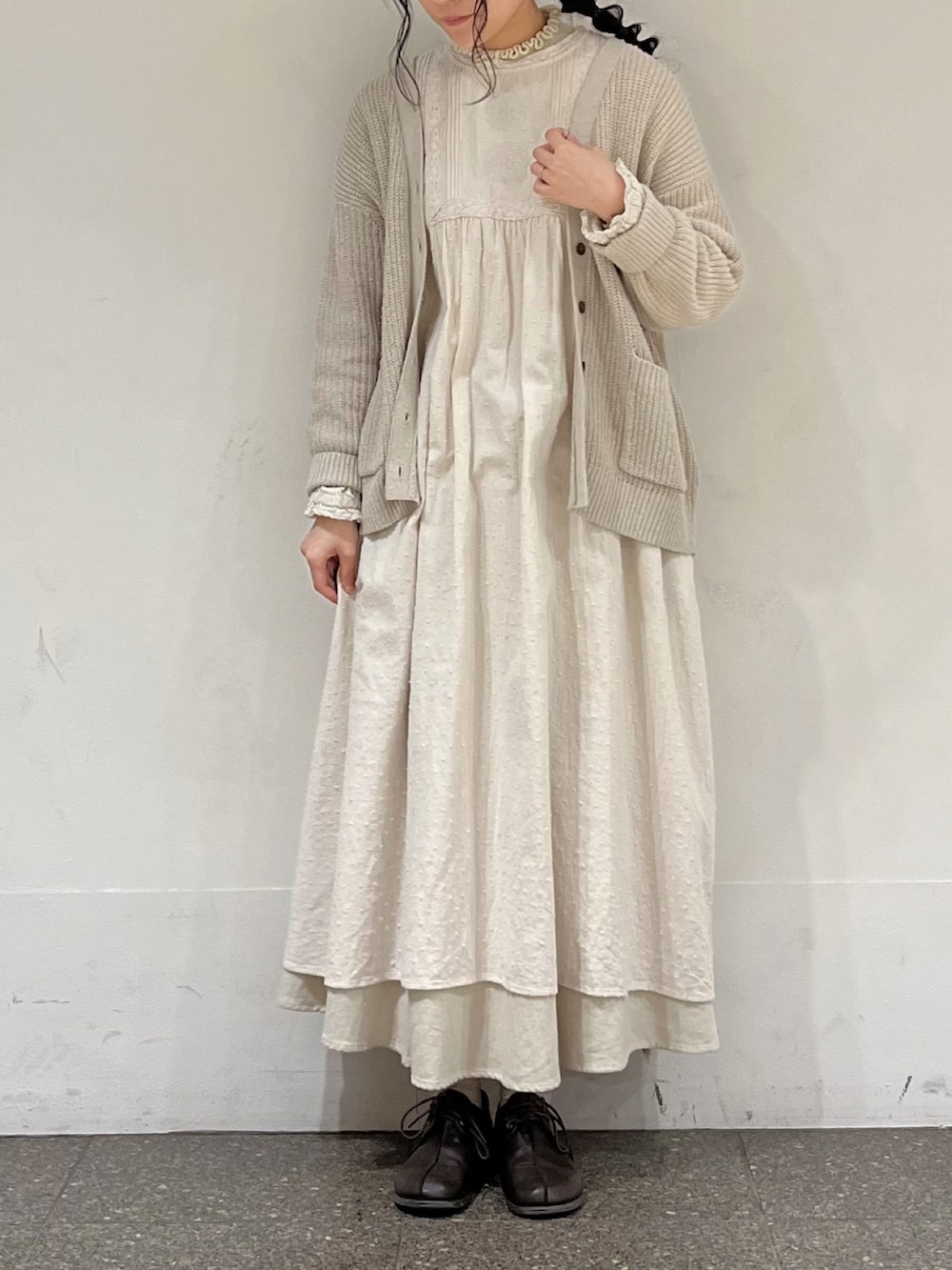 ホワイト系のワンピース、ホワイト系のニット/セーター、ベージュ系のスカートを着用したレディースの冬コーディネートの2枚目の写真