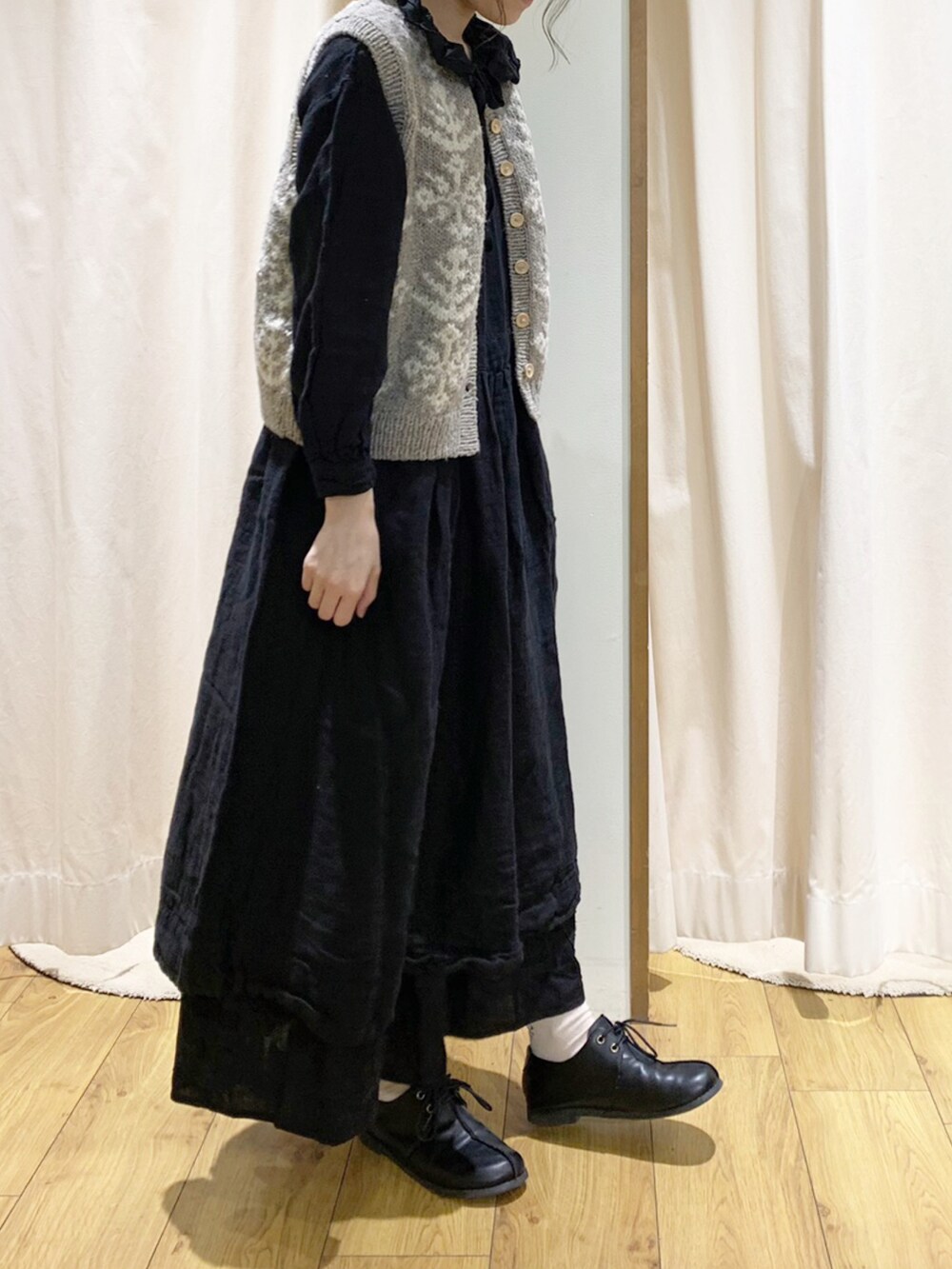 ブラック系のワンピース、ブラウン系のベスト、ブラック系のスカートを着用したレディースの秋コーディネートの3枚目の写真