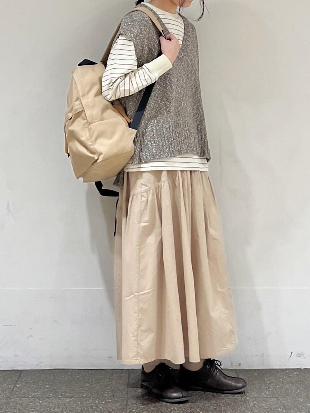 ベージュ系のTシャツ/カットソー、ブラウン系のベスト、ベージュ系のその他パンツを着用したレディースの冬コーディネートの2枚目の写真