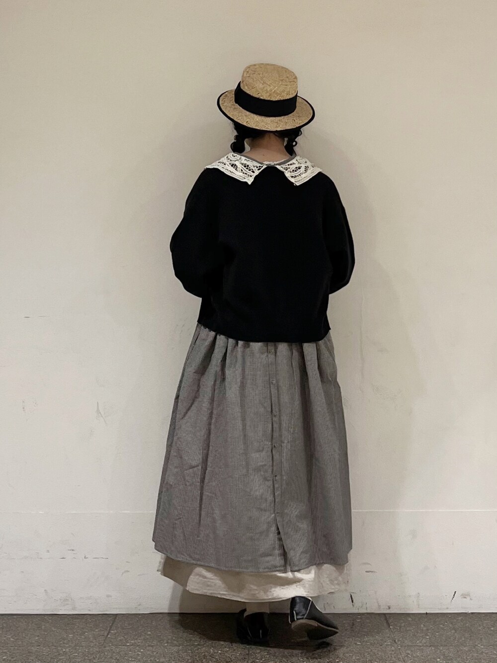 グレー系のワンピース、ブラック系のカーディガン/ボレロ、グレー系のスカートを着用したレディースの春コーディネートの4枚目の写真
