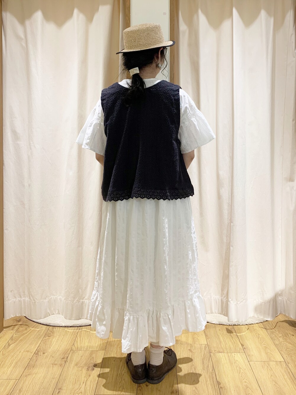 グレー系のベスト、ホワイト系のワンピース、ホワイト系のTシャツ/カットソーを着用したレディースの春コーディネートの4枚目の写真