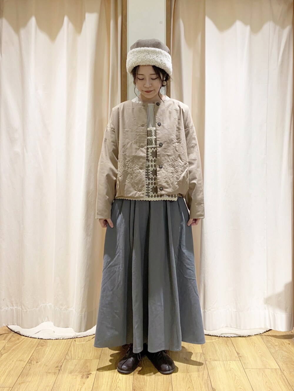 ホワイト系のベスト、ホワイト系のシャツ/ブラウス、グリーン系のスカートを着用したレディースの秋コーディネートの5枚目の写真