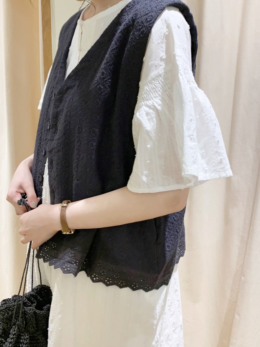 グレー系のベスト、ホワイト系のワンピース、ホワイト系のTシャツ/カットソーを着用したレディースの春コーディネートの5枚目の写真