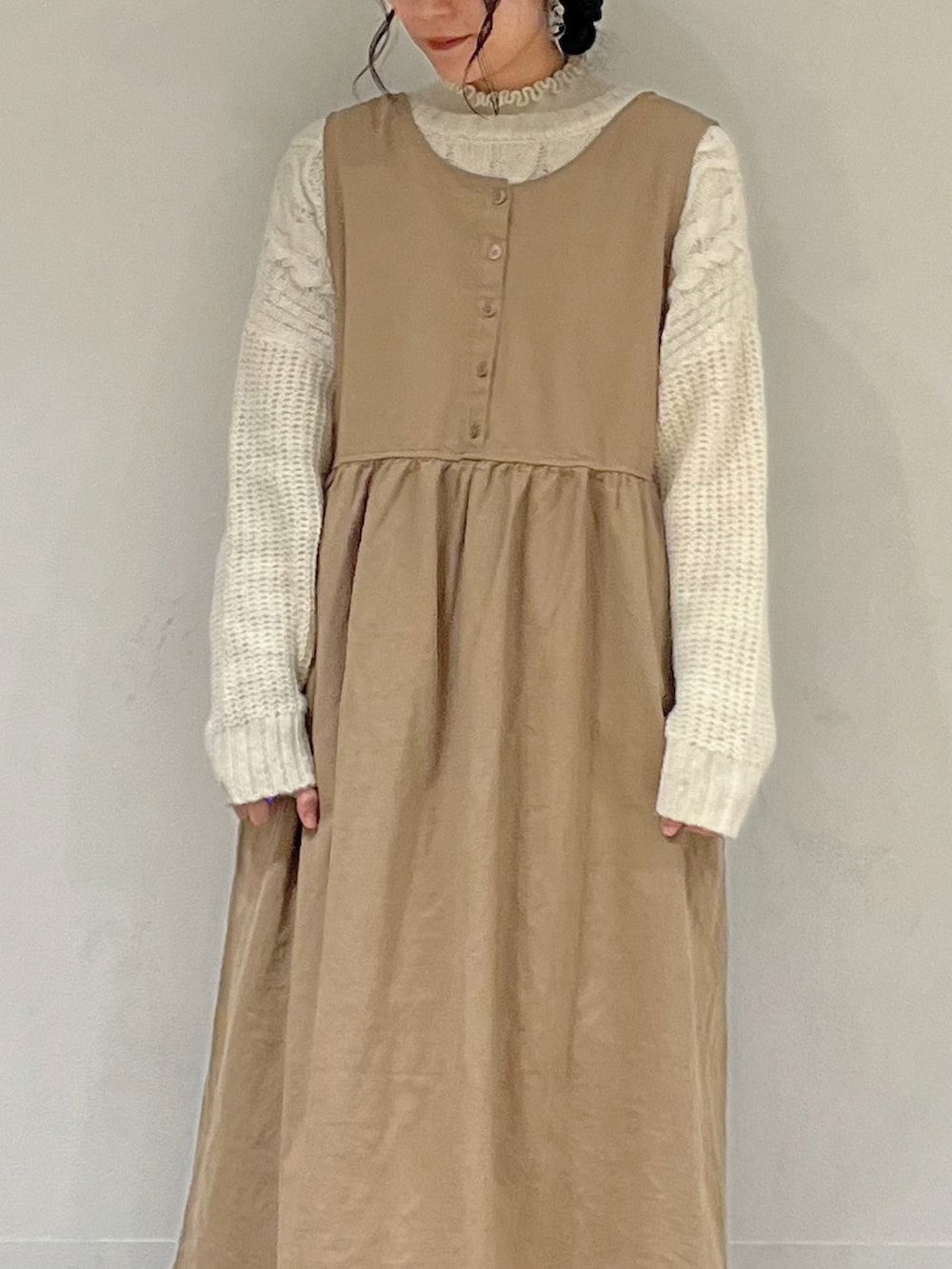 ホワイト系のカーディガン/ボレロ、ホワイト系のニット/セーター、ベージュ系のワンピースを着用したレディースの冬コーディネートの5枚目の写真