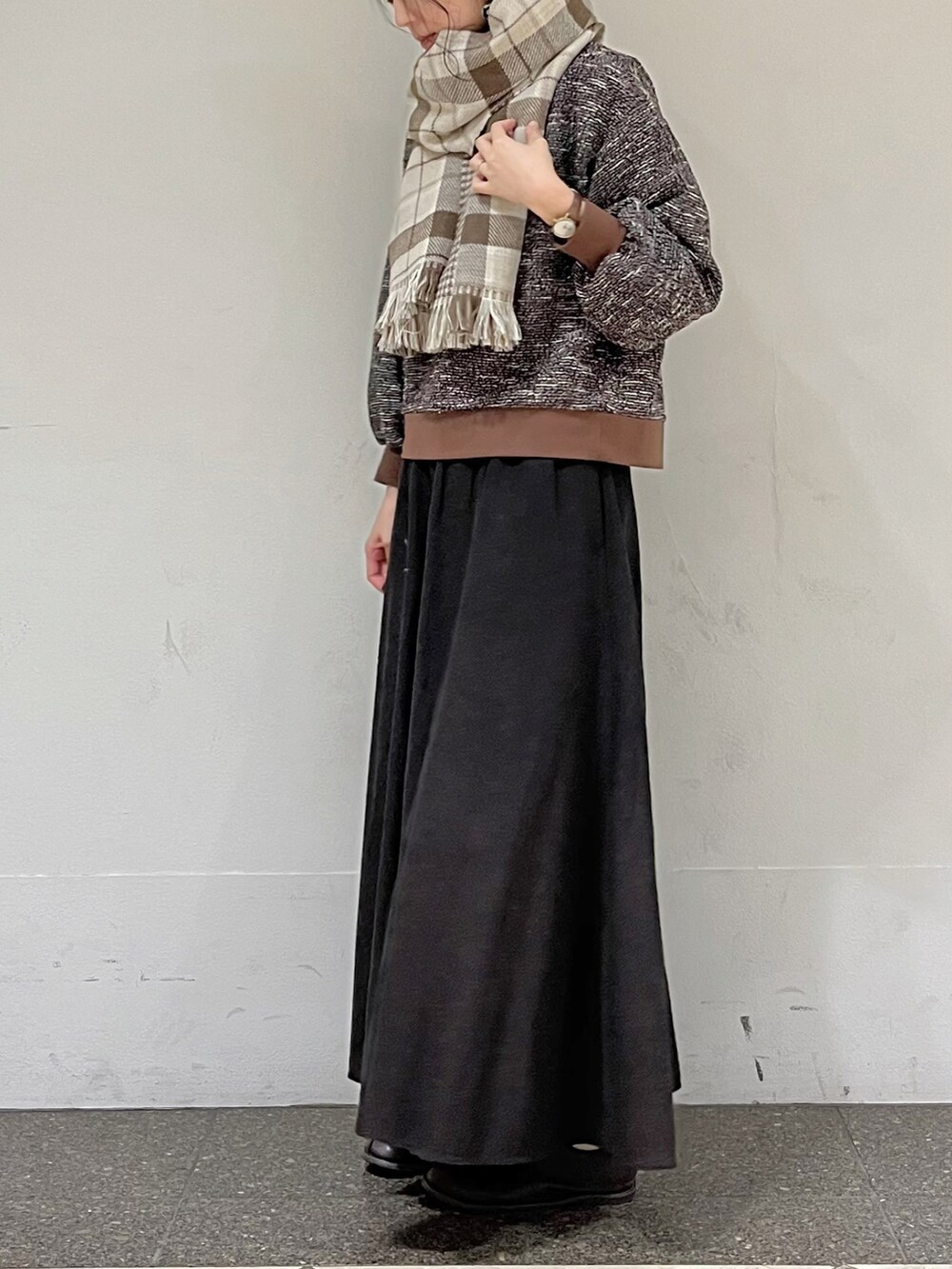 ブラウン系のTシャツ/カットソー、グレー系のスカート、ベージュ系のストール/ショールを着用したレディースの秋コーディネートの3枚目の写真