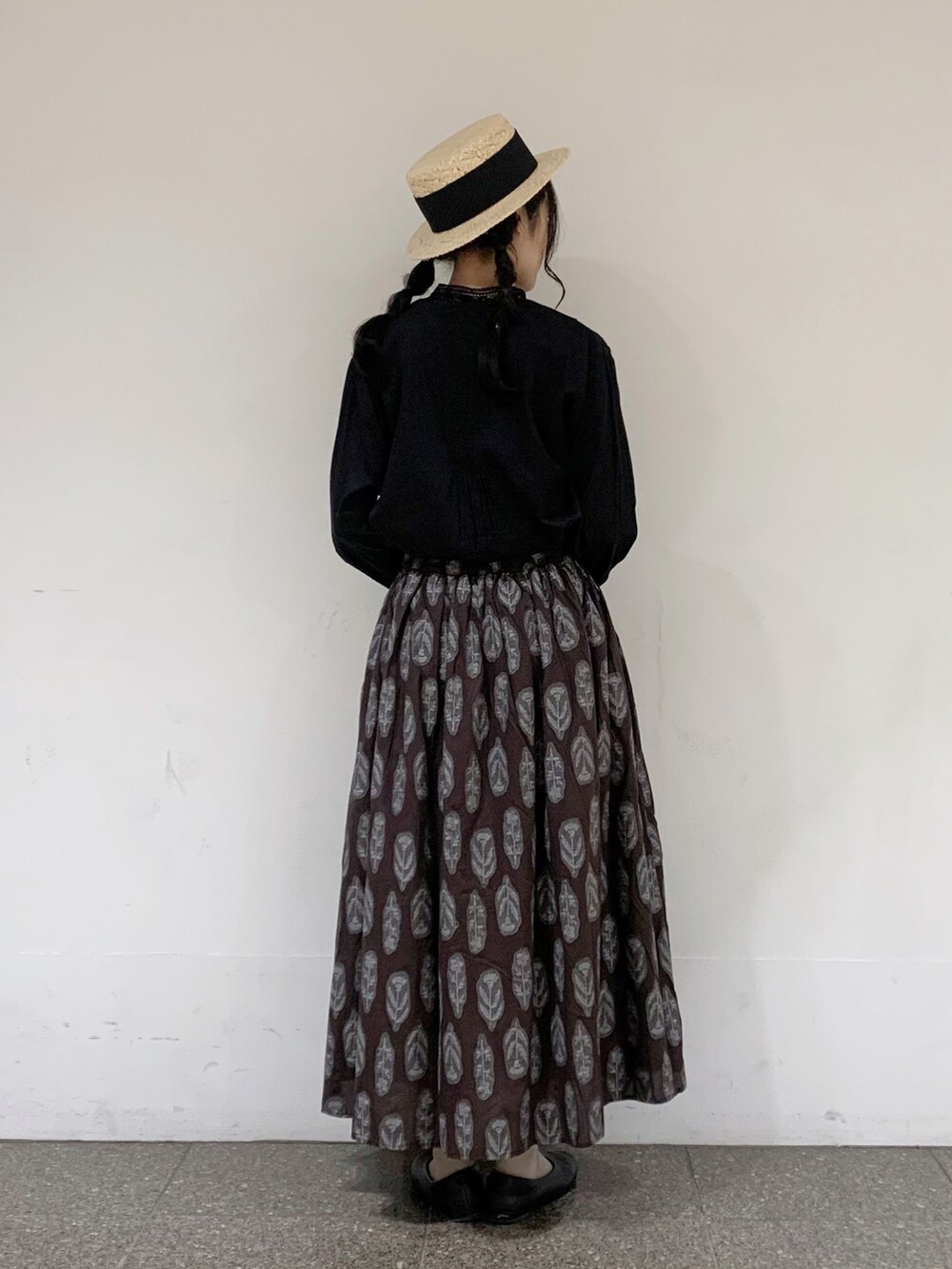 ブラック系のシャツ/ブラウス、ブラウン系のスカート、ベージュ系のハンドバッグを着用したレディースの夏コーディネートの3枚目の写真