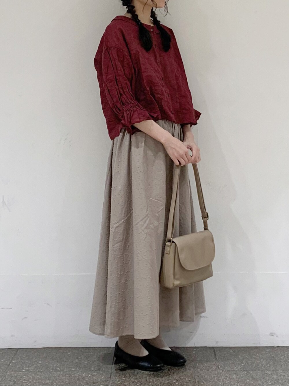 レッド系のシャツ/ブラウス、ベージュ系のスカート、ベージュ系のハンドバッグを着用したレディースの夏コーディネートの2枚目の写真