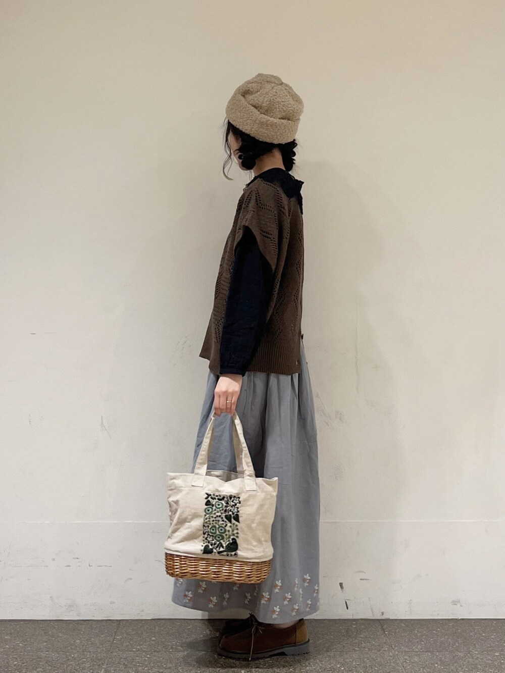 ブラック系のシャツ/ブラウス、ブラウン系のベスト、ブルー系のスカートを着用したレディースの秋コーディネートの4枚目の写真