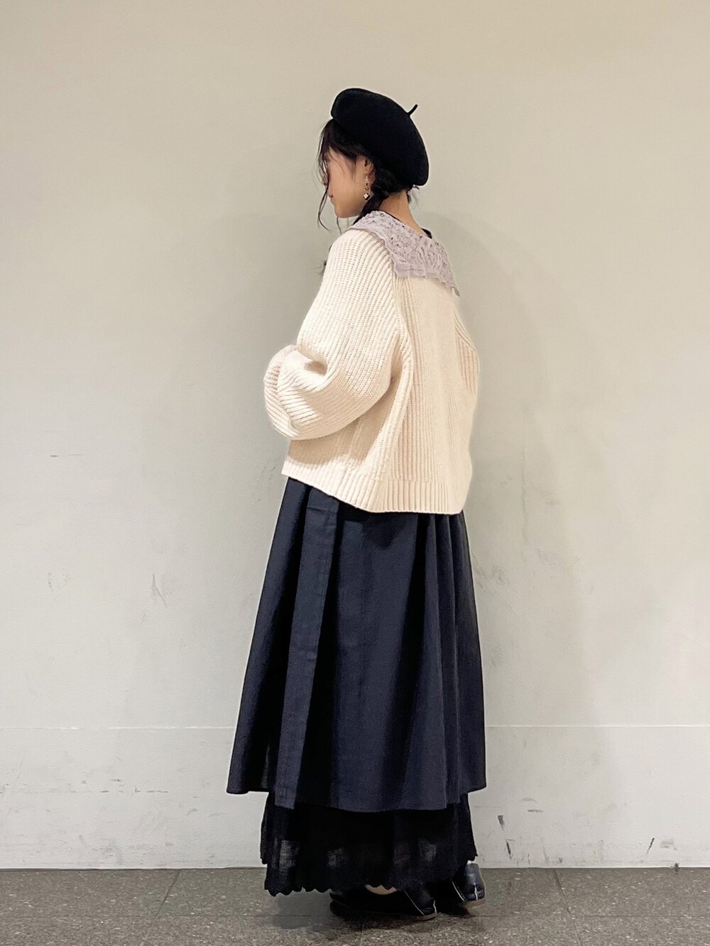 ブラック系のワンピース、ベージュ系のカーディガン/ボレロ、ブラック系のスカートを着用したレディースの春コーディネートの3枚目の写真