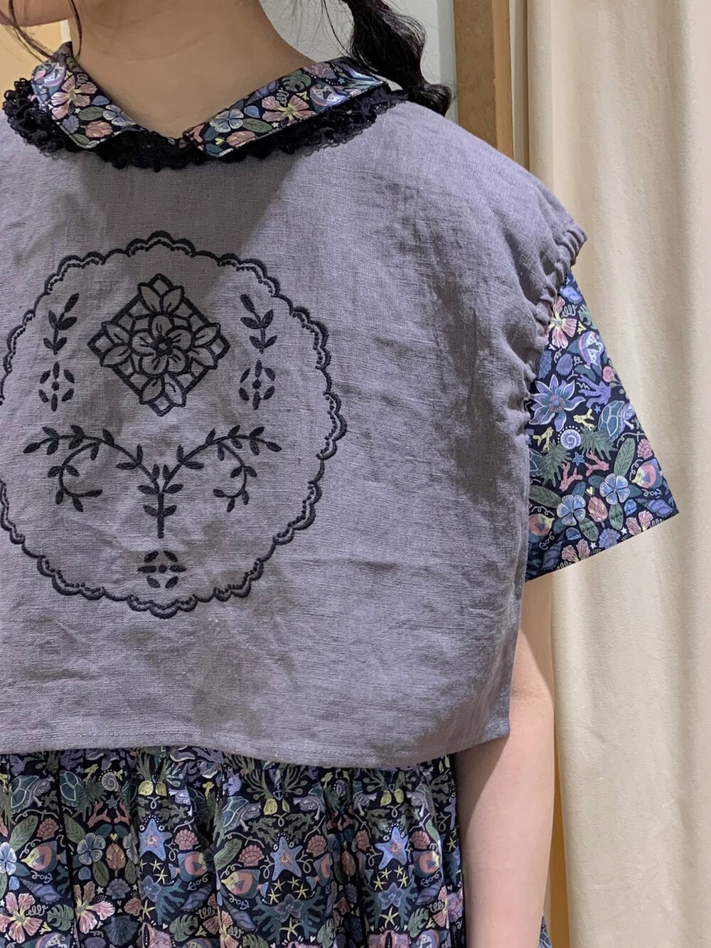 ブルー系のワンピース、グレー系のベスト、ホワイト系のスカートを着用したレディースの春コーディネートの4枚目の写真