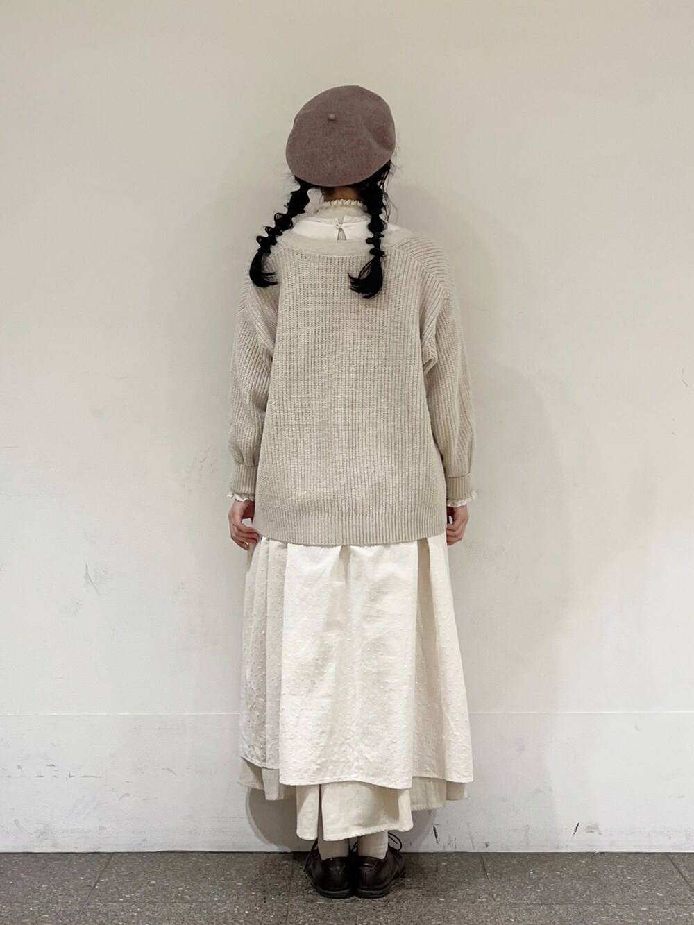 ホワイト系のワンピース、ホワイト系のニット/セーター、ベージュ系のスカートを着用したレディースの冬コーディネートの4枚目の写真