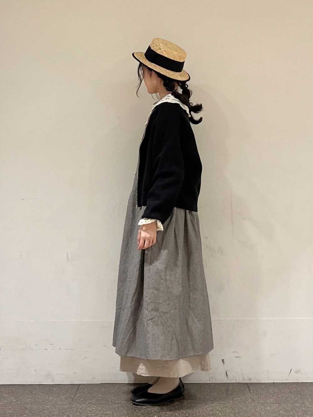 グレー系のワンピース、ブラック系のカーディガン/ボレロ、グレー系のスカートを着用したレディースの春コーディネートの3枚目の写真