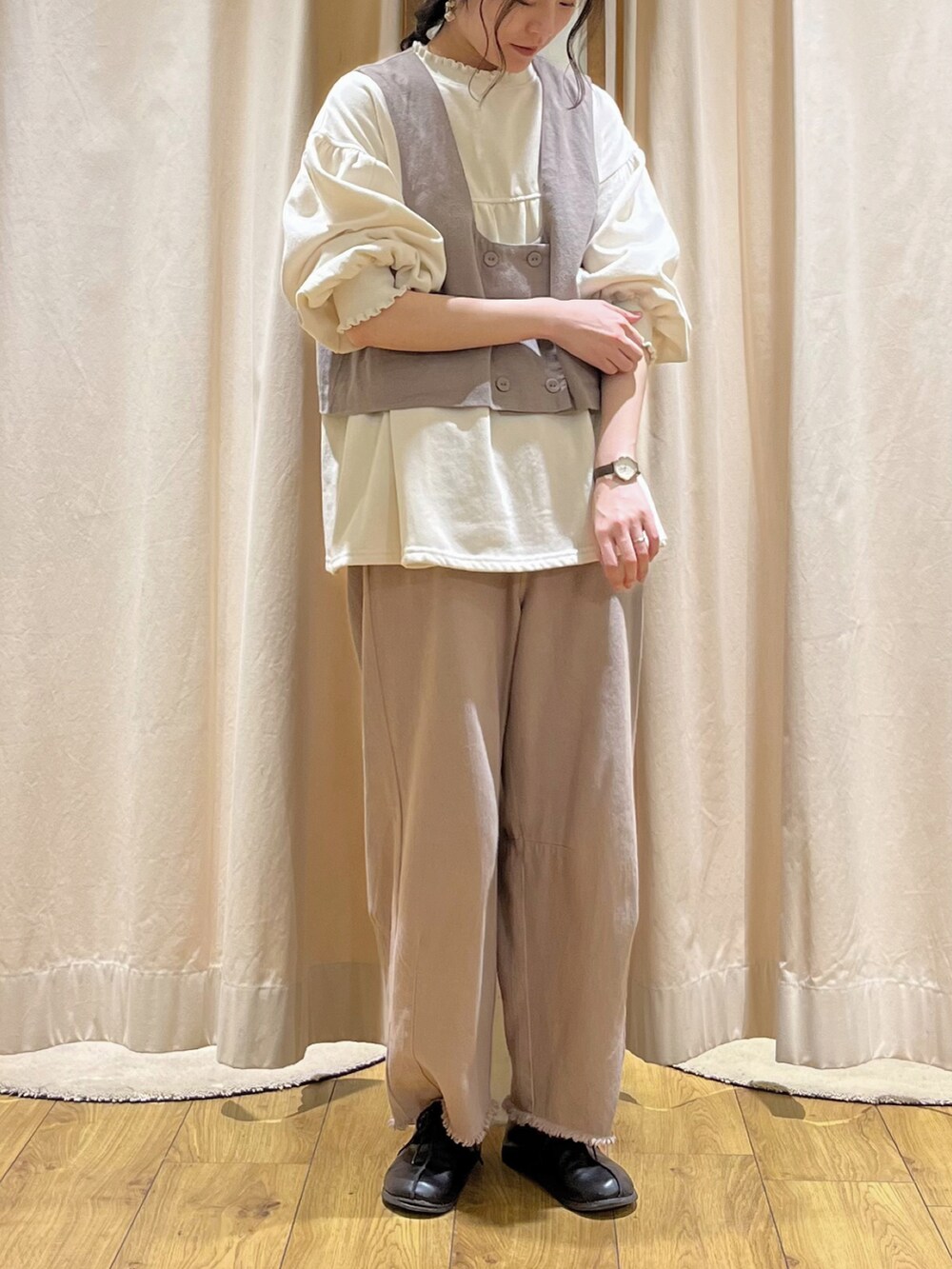 ホワイト系のTシャツ/カットソー、ブラウン系のベスト、ベージュ系のその他パンツを着用したレディースの冬コーディネートの2枚目の写真