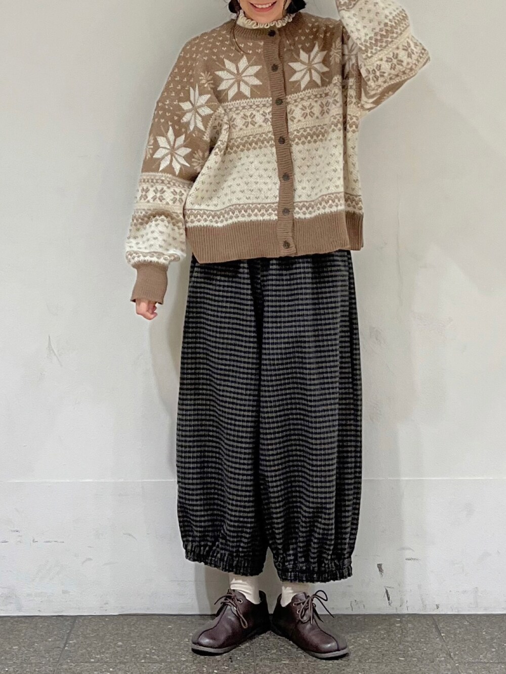 ブラウン系のカーディガン/ボレロ、ホワイト系のニット/セーター、ブラウン系のその他パンツを着用したレディースの冬コーディネートの5枚目の写真
