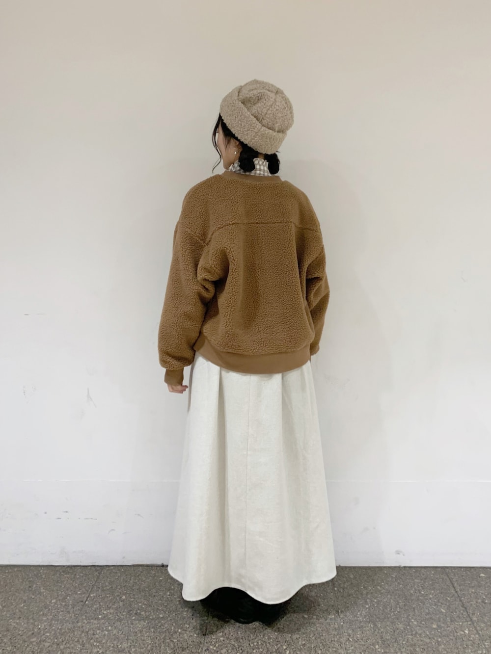 イエロー系のブルゾン、ベージュ系のシャツ/ブラウス、ベージュ系のスカートを着用したレディースの冬コーディネートの4枚目の写真