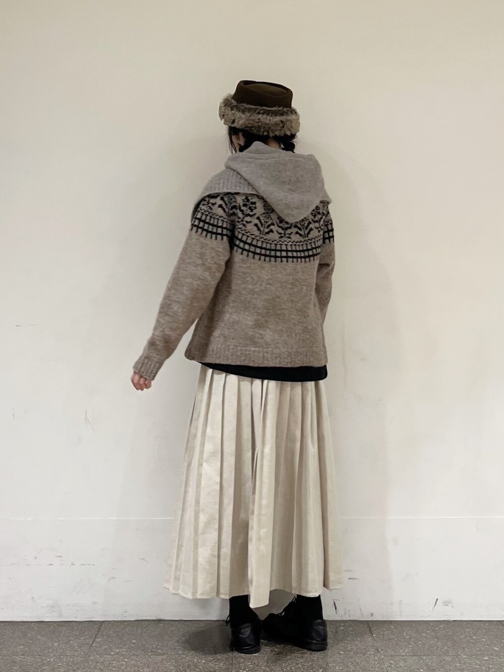 ブラウン系のカーディガン/ボレロ、ブラック系のシャツ/ブラウス、ベージュ系のスカートを着用したレディースの冬コーディネートの3枚目の写真