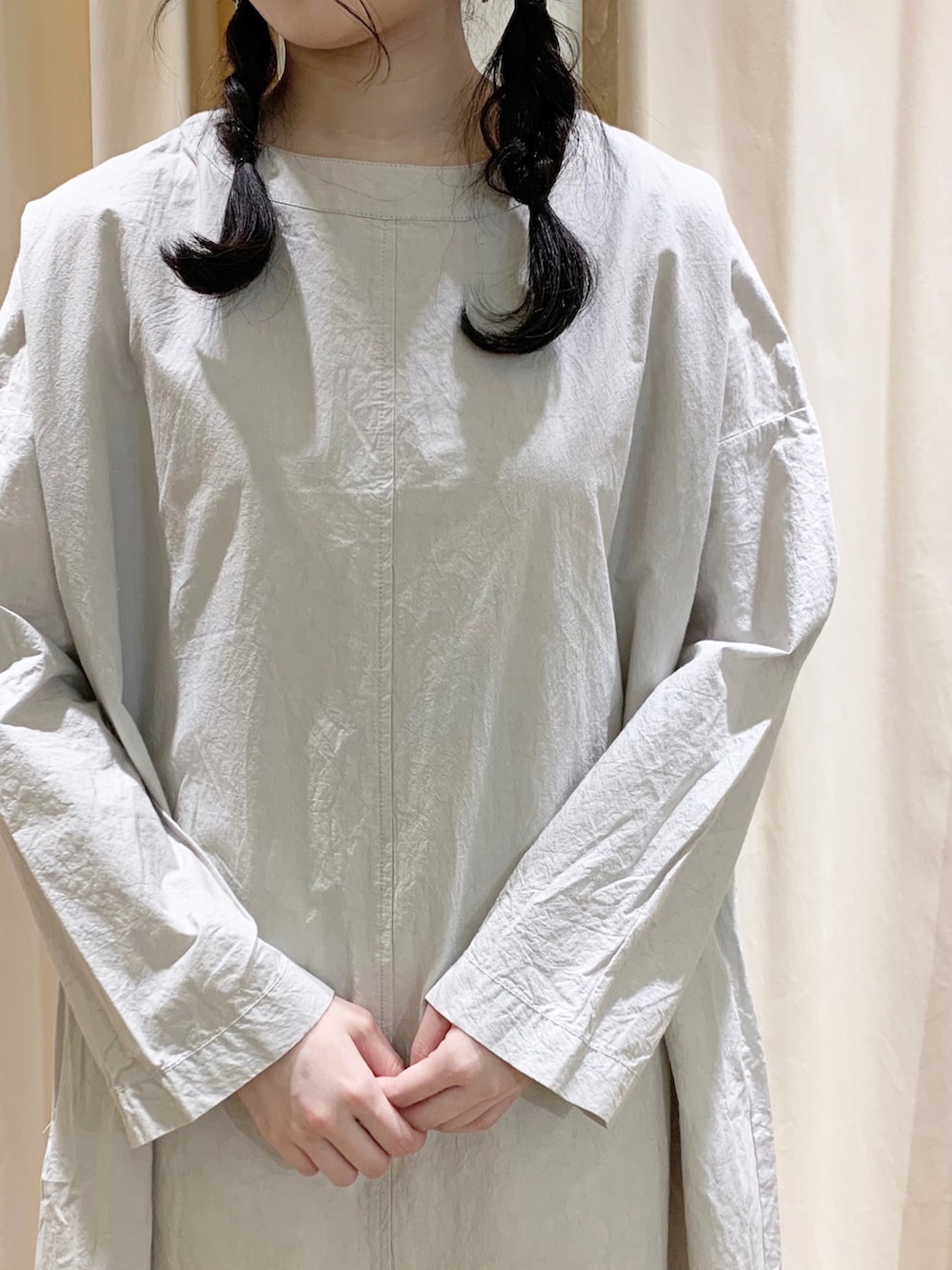 グレー系のワンピース、ブラック系のサンダル、ホワイト系のスカートを着用したレディースの春コーディネートの5枚目の写真