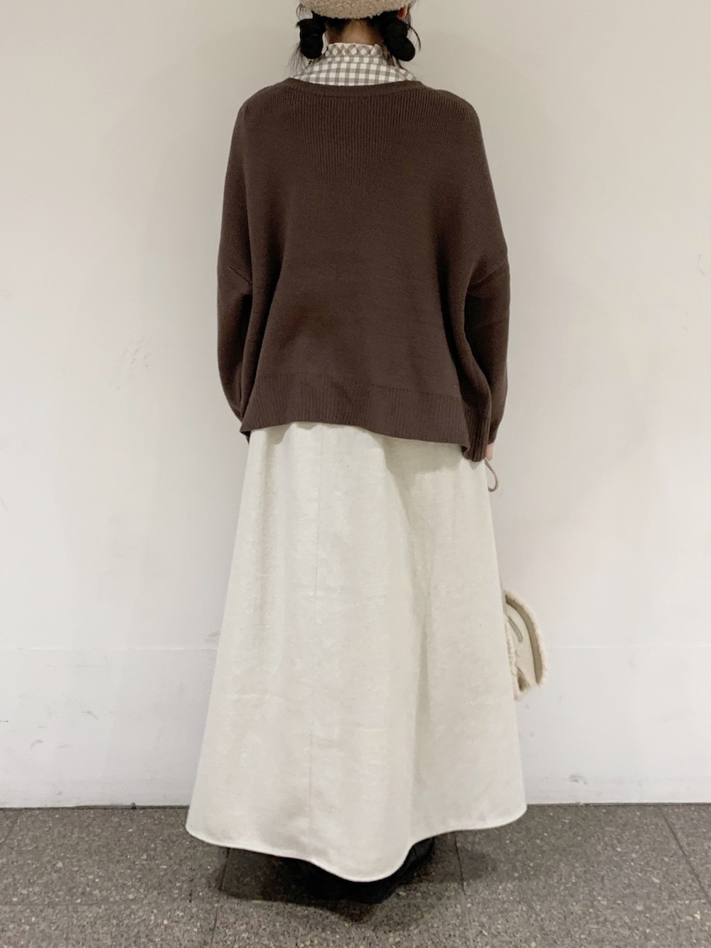 ブラウン系のニット/セーター、ベージュ系のシャツ/ブラウス、ベージュ系のスカートを着用したレディースの冬コーディネートの4枚目の写真