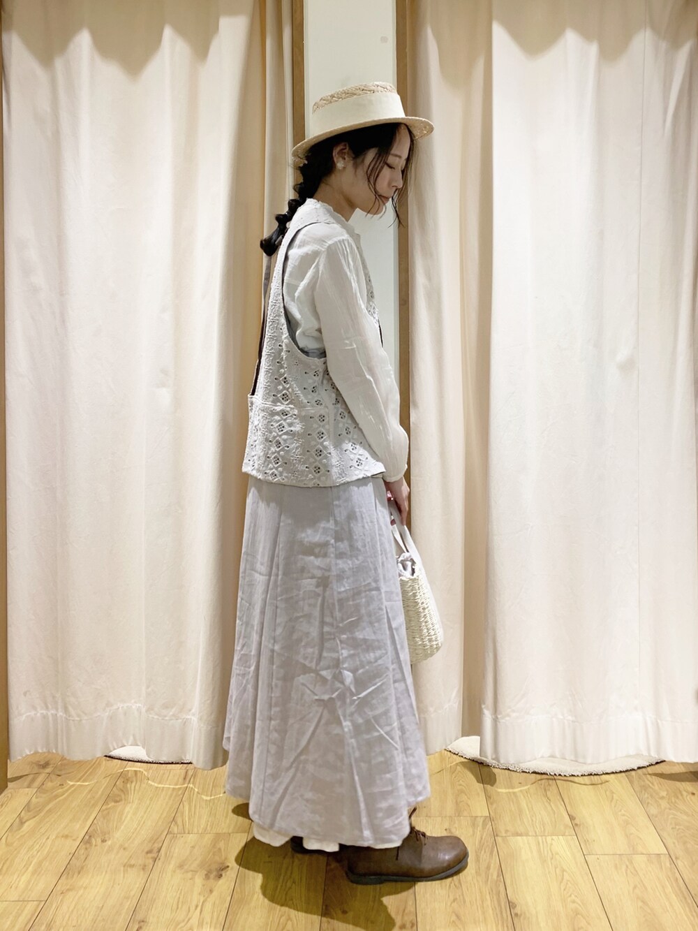 グレー系のワンピース、ホワイト系のベスト、ホワイト系のスカートを着用したレディースの春コーディネートの3枚目の写真