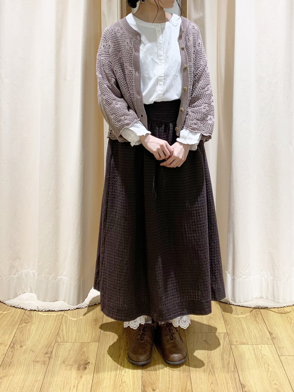 ホワイト系のシャツ/ブラウス、ブラウン系のカーディガン/ボレロ、グレー系のスカートを着用したレディースの春コーディネートの2枚目の写真