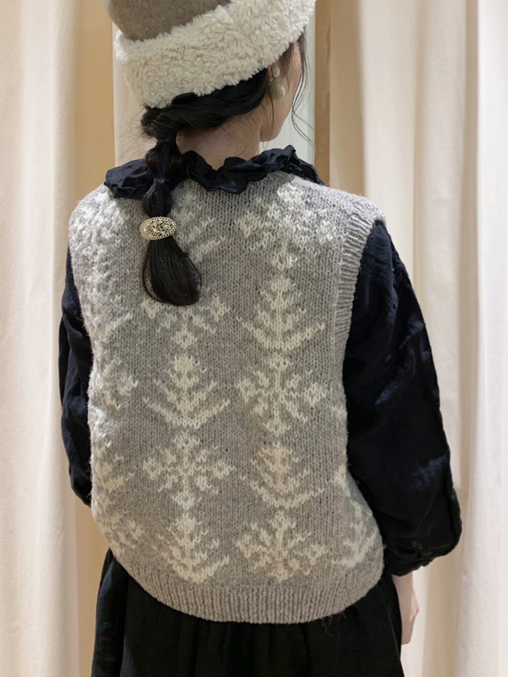 ブラック系のワンピース、ブラウン系のベスト、ブラック系のスカートを着用したレディースの秋コーディネートの5枚目の写真